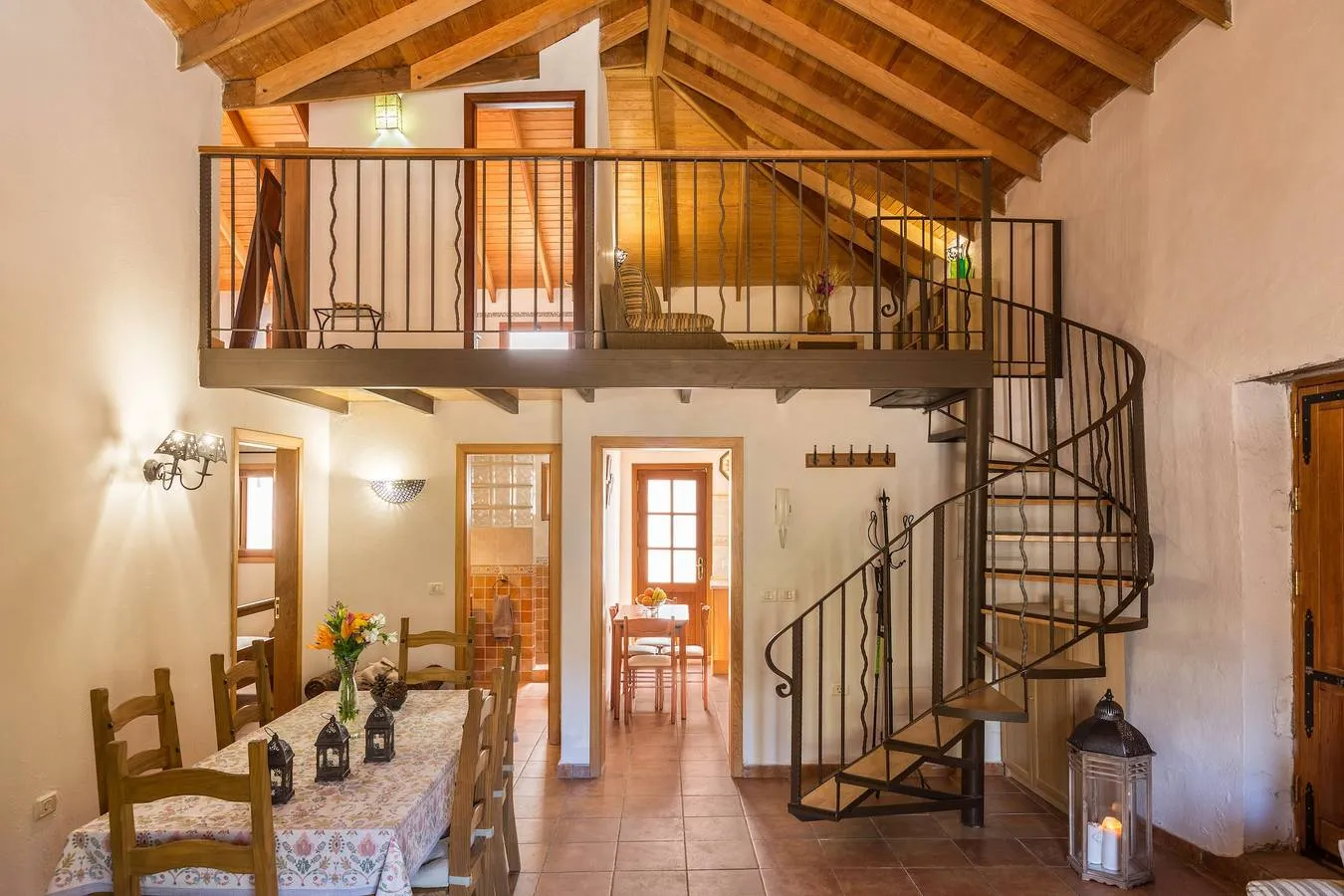 Salón con techo de madera y escalera de caracol a la buhardilla