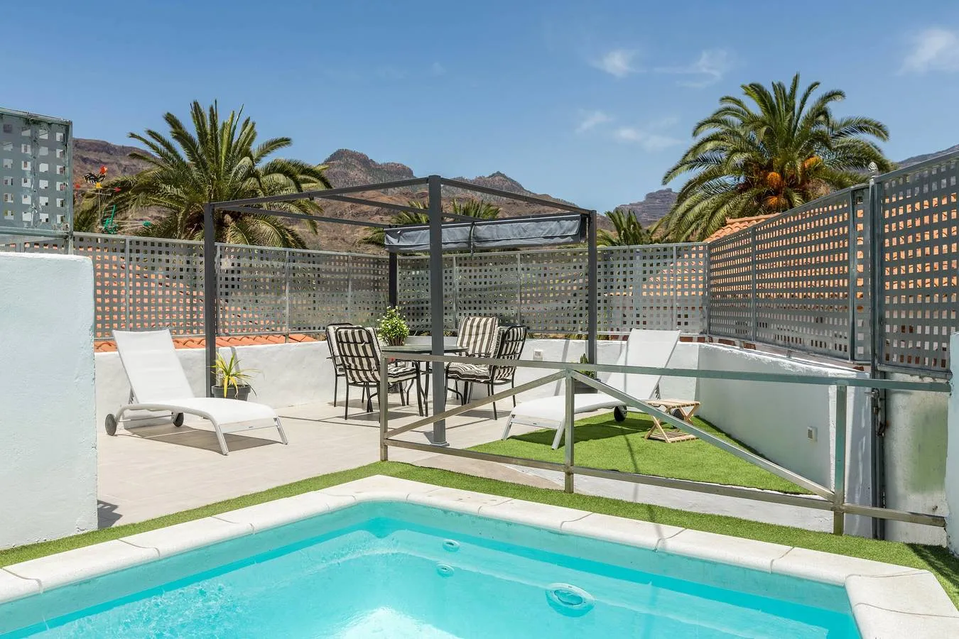 Piscina privada de Casa La Huertecilla con palmeras y montañas al fondo
